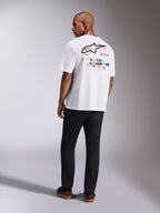 Alpinestars Wild Oversized CSF Tee, t-shirt a maniche corte, bianco, vista posteriore del modello che indossa la t-shirt oversize con vivace logo Astars multicolore e scritte sul retro, streetwear casual ispirato al motorsport