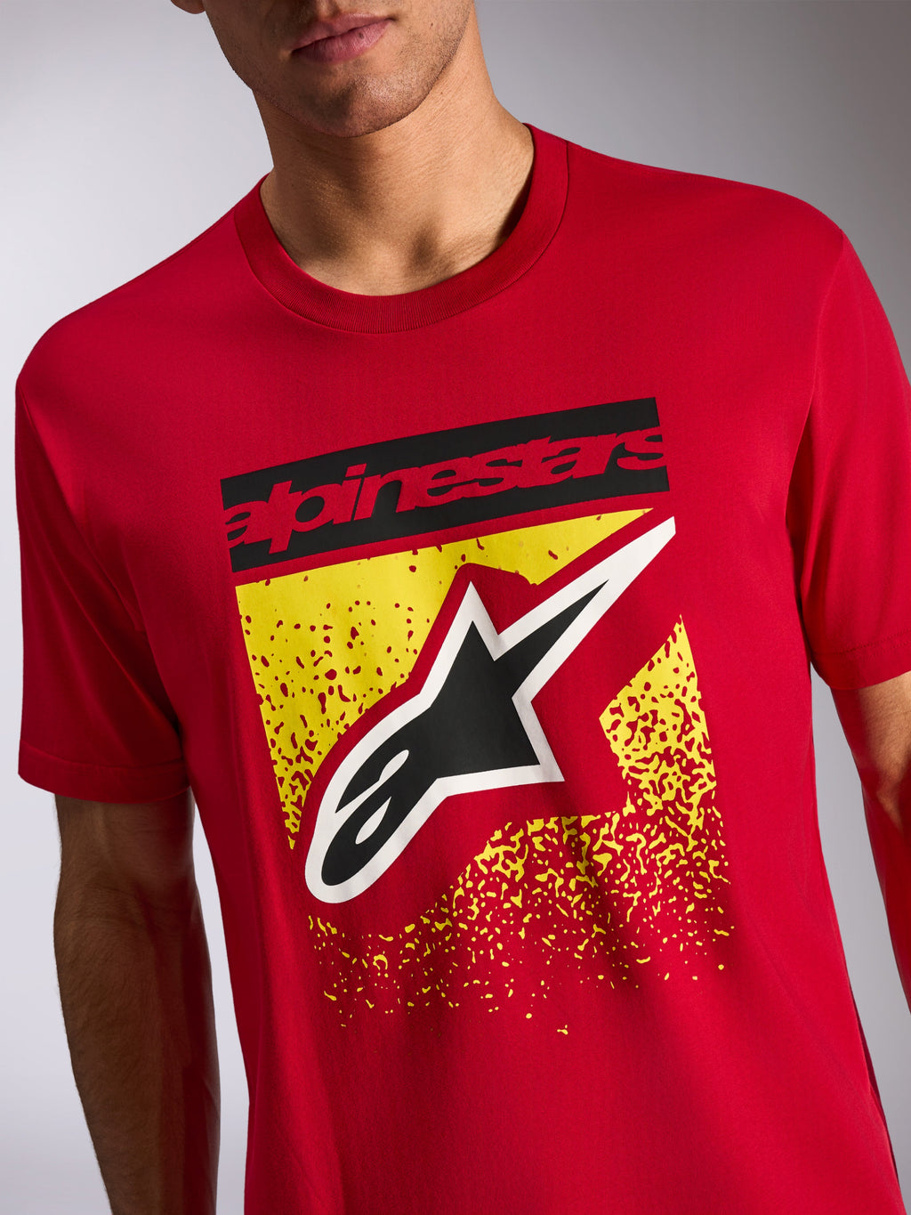 Alpinestars Noka CSF Tee, t-shirt a maniche corte, rosso, grafica frontale con scritta Alpinestars nera e logo Astars su design giallo puntinato, streetwear casual motorsport