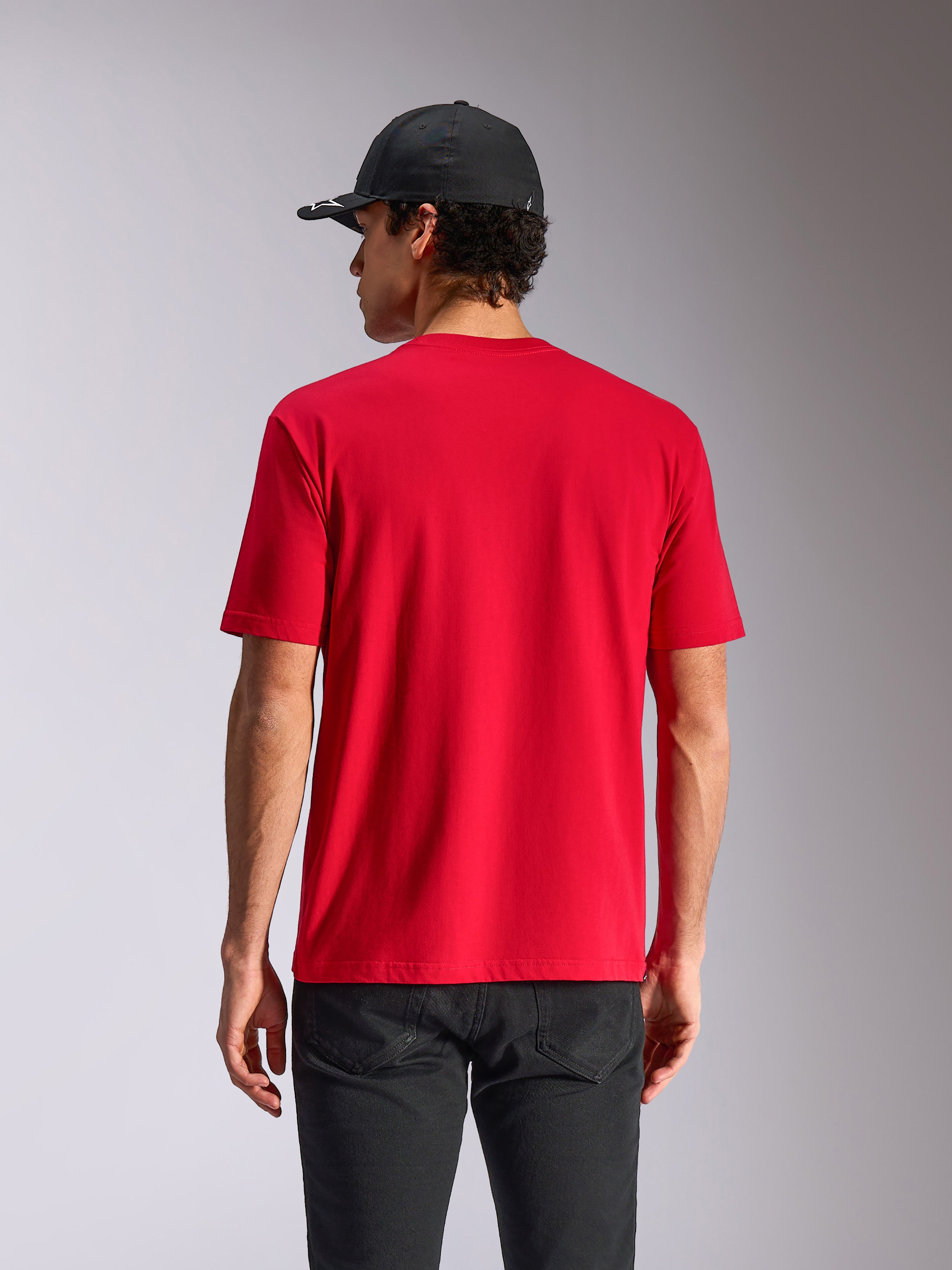Alpinestars Noka CSF Tee, t-shirt a maniche corte, rosso, vista posteriore su modello, streetwear casual motorsport, abbinata a cappellino nero e pantaloni scuri