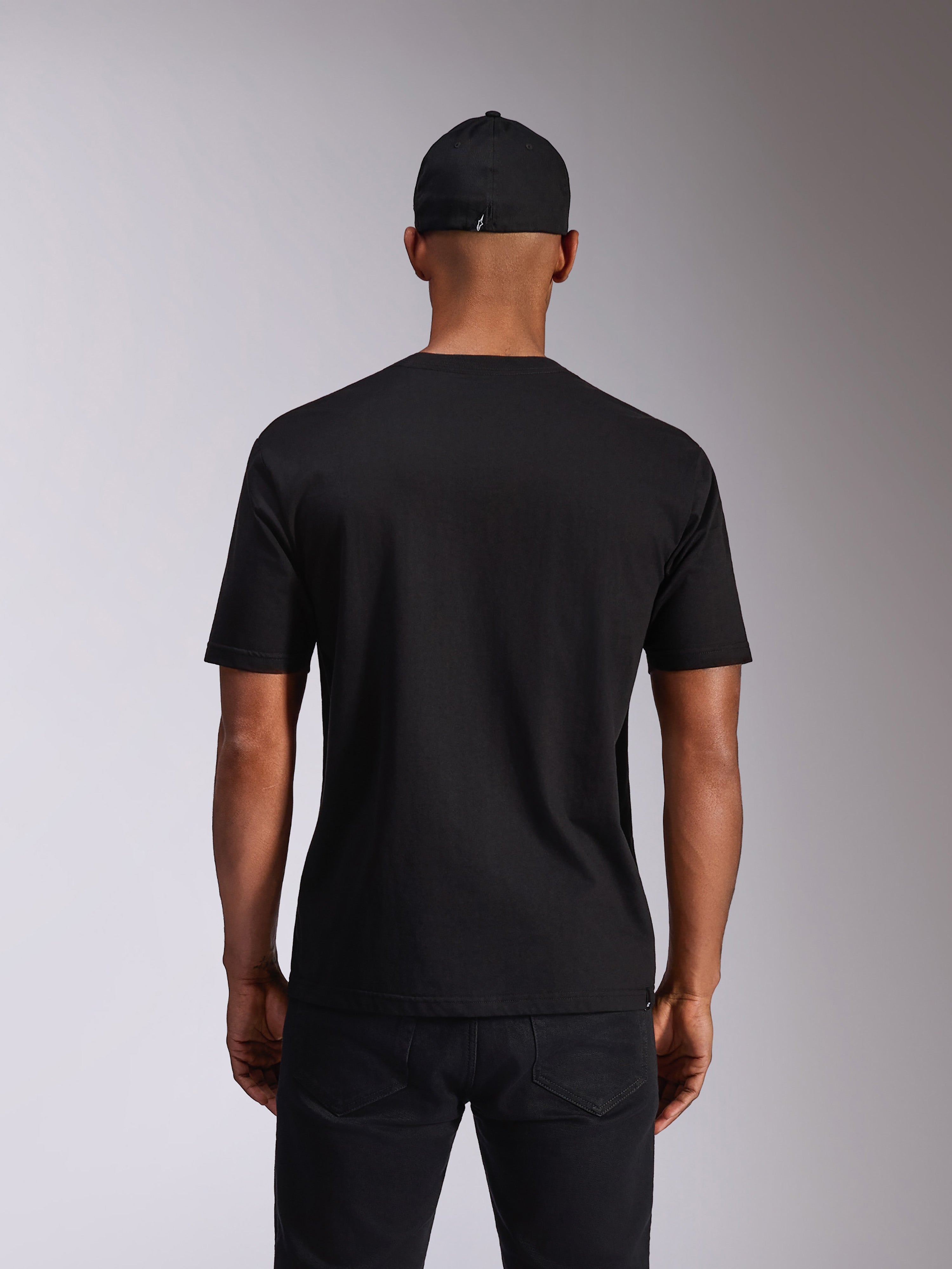 Alpinestars Ellipsoid CSF Tee, maglietta a maniche corte, nero, vista posteriore sul modello, indossata con cappellino nero e pantaloni scuri, streetwear casual ispirato al motorsport