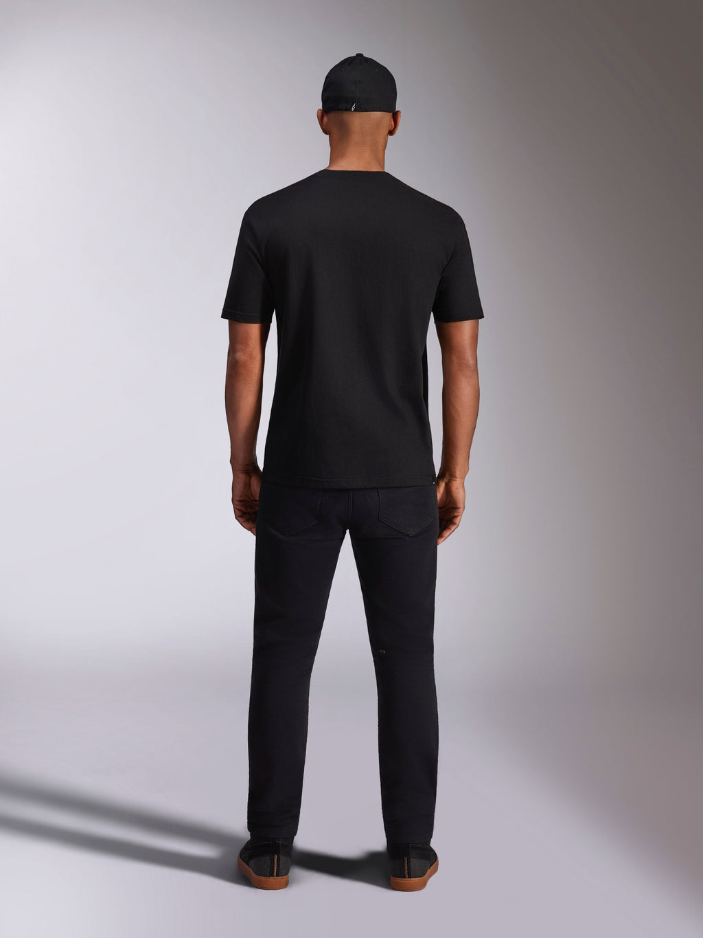 Alpinestars Ellipsoid CSF Tee, maglietta a maniche corte, nero, vista posteriore indossata da un modello con cappellino e pantaloni neri, streetwear casual ispirato al motorsport