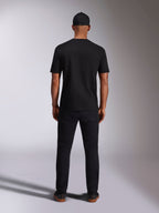 Alpinestars Ellipsoid CSF Tee, maglietta a maniche corte, nero, vista posteriore indossata da un modello con cappellino e pantaloni neri, streetwear casual ispirato al motorsport