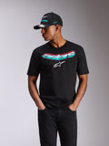 Alpinestars Ellipsoid CSF Tee, maglietta a maniche corte, nera, scritta Astars con sfumatura verde acqua e rosa e logo bianco, indossata da un modello con cappellino Alpinestars abbinato e jeans neri, streetwear casual motorsport