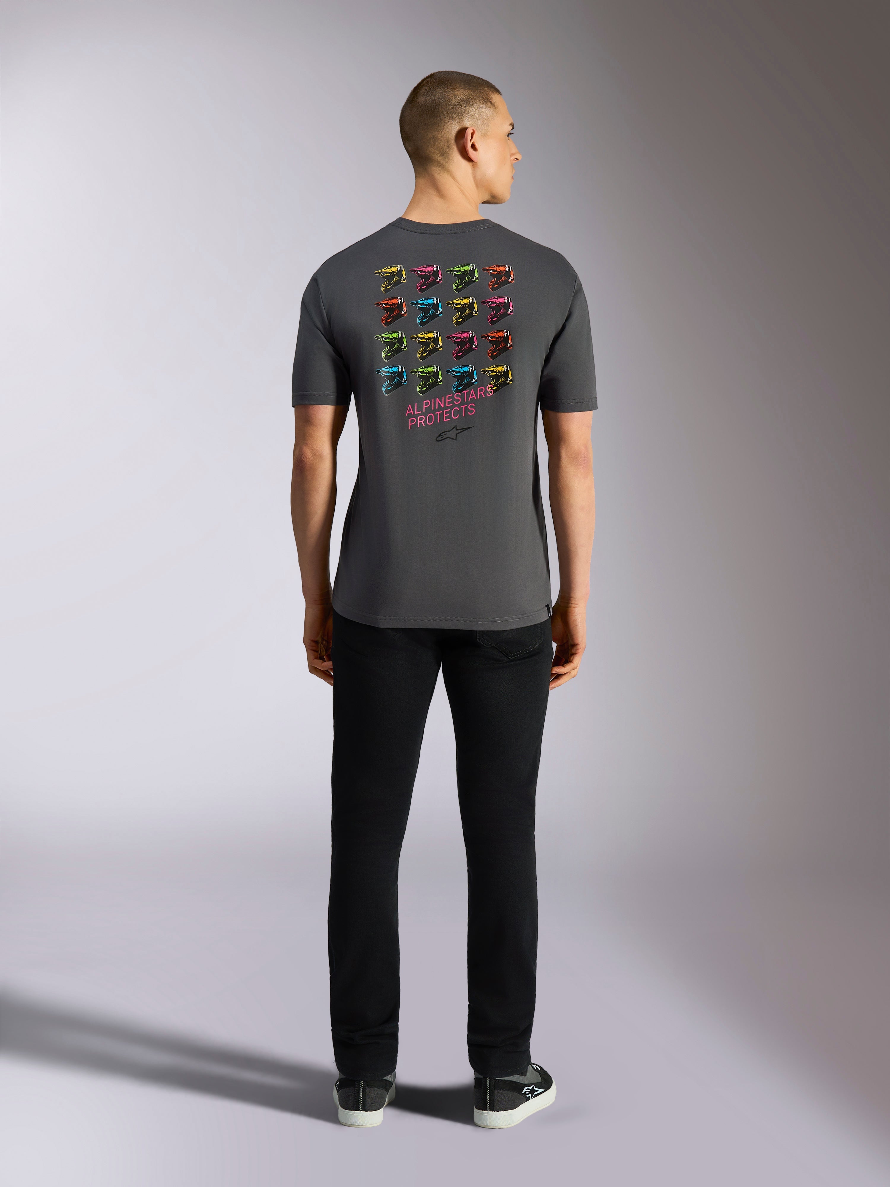 Alpinestars Pop Helmet CSF Tee, maglietta a maniche corte, grigio antracite, con griglia di grafiche multicolore del casco M10 sul retro e scritta 'ALPINESTARS PROTECTS', abbigliamento streetwear casual da motorsport
