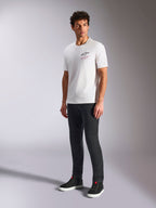 Alpinestars Pop Helmet CSF Tee, T-shirt a maniche corte, bianco, con logo Astars frontale e scritta rossa, indossata da un modello con pantaloni scuri e sneakers nere, streetwear casual motorsport