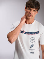 Alpinestars Abus CSF Tee, t-shirt a maniche corte, bianca, con logo Alpinestars curvo blu navy con contorno rosso e grafiche multiple impilate, abbigliamento casual motorsport streetwear
