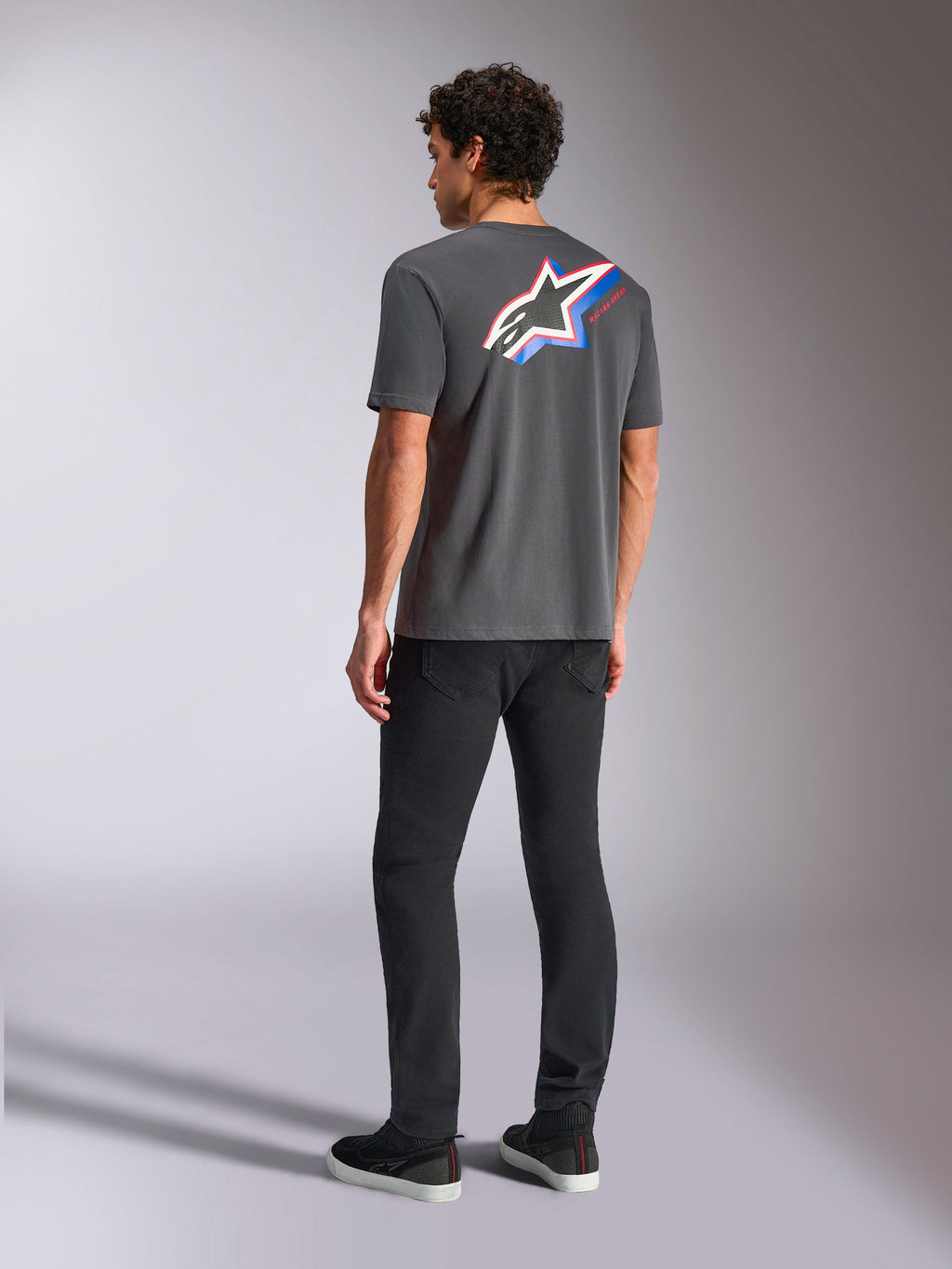 Alpinestars Angler CSF Tee, maglietta a maniche corte, grigio antracite, logo Astars multicolore vibrante sul retro con strisce rosse e blu, streetwear casual motorsport