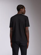 Alpinestars Authority CSF Tee, t-shirt a maniche corte, nera, vista posteriore su modello che indossa jeans scuri, design semplice dalla finitura pulita, streetwear casual motorsport
