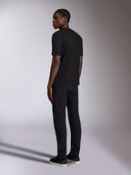 Alpinestars Authority CSF Tee, t-shirt a maniche corte, nero, vista posteriore indossata da un modello, streetwear casual d'ispirazione motorsport, abbinata a pantaloni neri