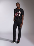 Alpinestars Authority CSF Tee, t-shirt a maniche corte, nero, grande logo Astars ritagliato con contorni rossi e bianchi, indossata da un modello, abbigliamento casual motorsport streetwear
