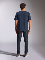 Alpinestars Trifecta CSF Tee, t-shirt a maniche corte, blu navy, vista posteriore su modello, abbinata a jeans in denim scuro e sneakers casual, streetwear casual motorsport