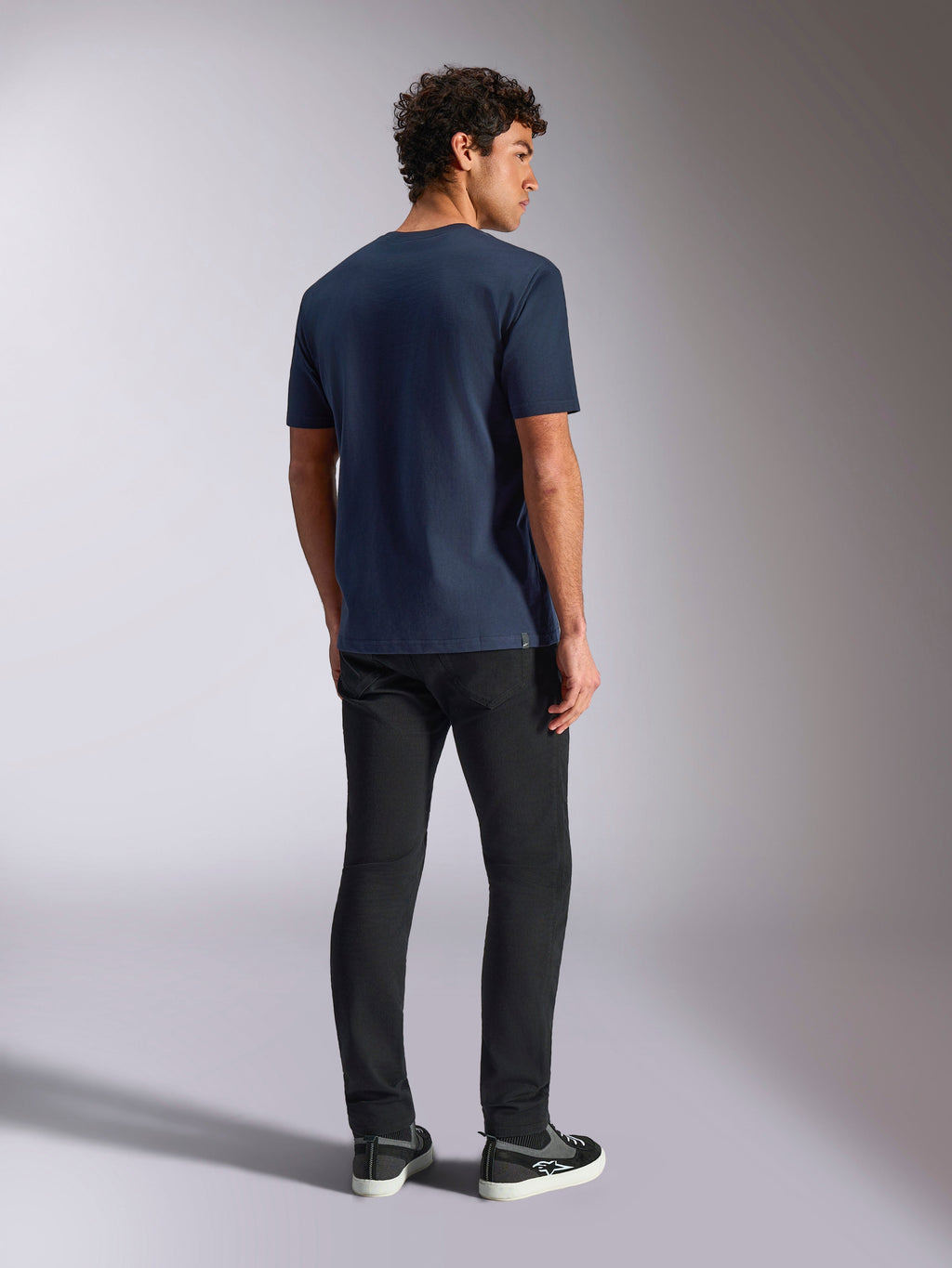 Alpinestars Trifecta CSF Tee, t-shirt a maniche corte, blu navy, vista posteriore, abbigliamento sportivo casual, indossata con pantaloni neri e sneakers nere