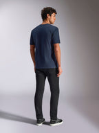 Alpinestars Trifecta CSF Tee, t-shirt a maniche corte, blu navy, vista posteriore, abbigliamento sportivo casual, indossata con pantaloni neri e sneakers nere