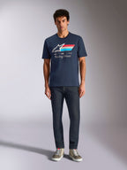 Alpinestars Trifecta CSF Tee, t-shirt a maniche corte, blu navy, logo Astars bianco con strisce rosse, bianche e azzurre e scritta 'Racing Ahead', indossata con jeans scuri e sneakers verde oliva, abbigliamento casual motorsport streetwear