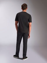 Alpinestars Trifecta CSF Tee, t-shirt a maniche corte, nero, vista posteriore su modello, indossata con pantaloni neri e sneakers nere, streetwear casual ispirato al motorsport