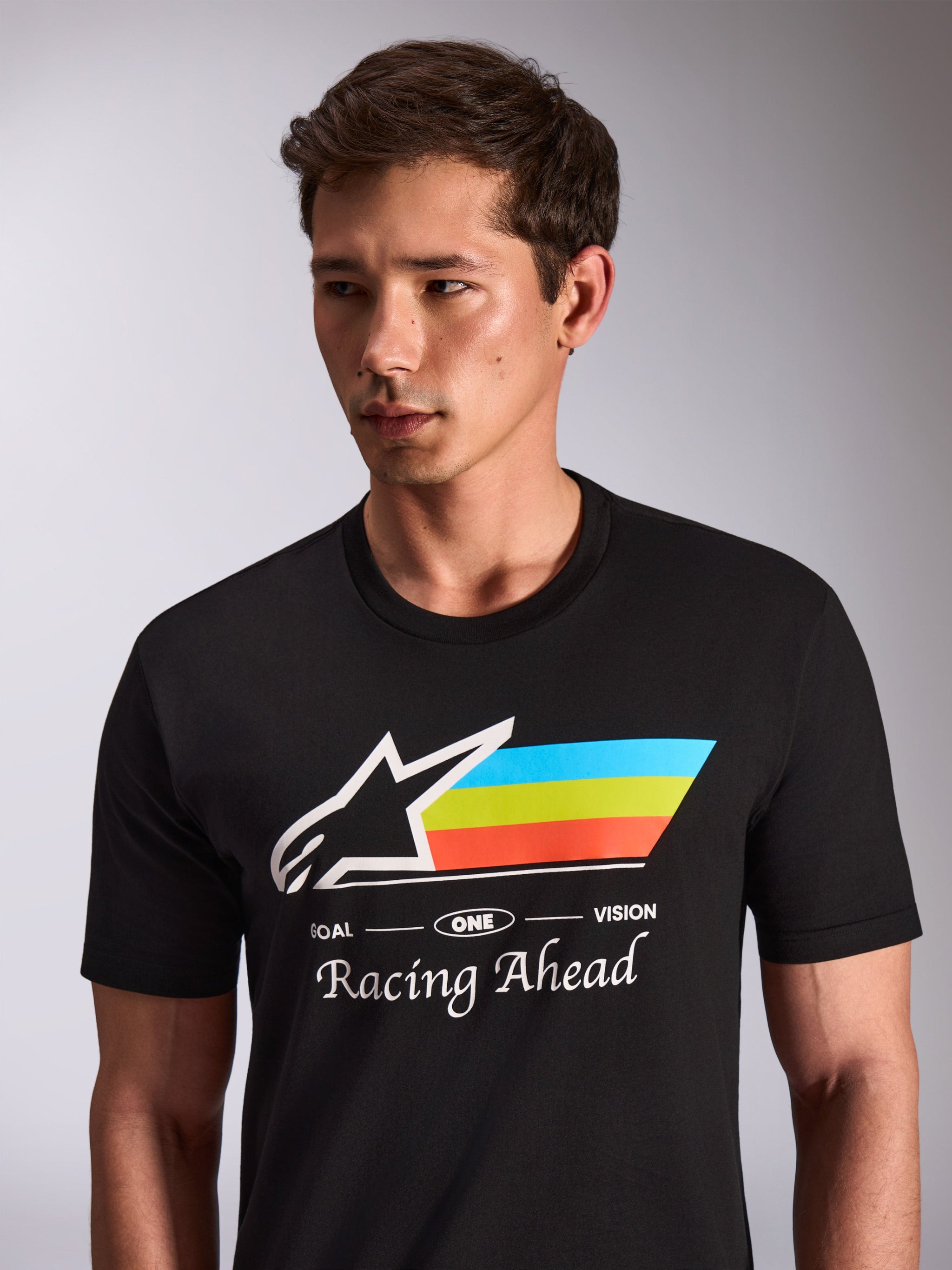 Alpinestars Trifecta CSF Tee, t-shirt a maniche corte, nero, logo Astars bianco con strisce blu, gialle e arancioni, grafica Racing Ahead, abbigliamento sportivo casual da motorsport