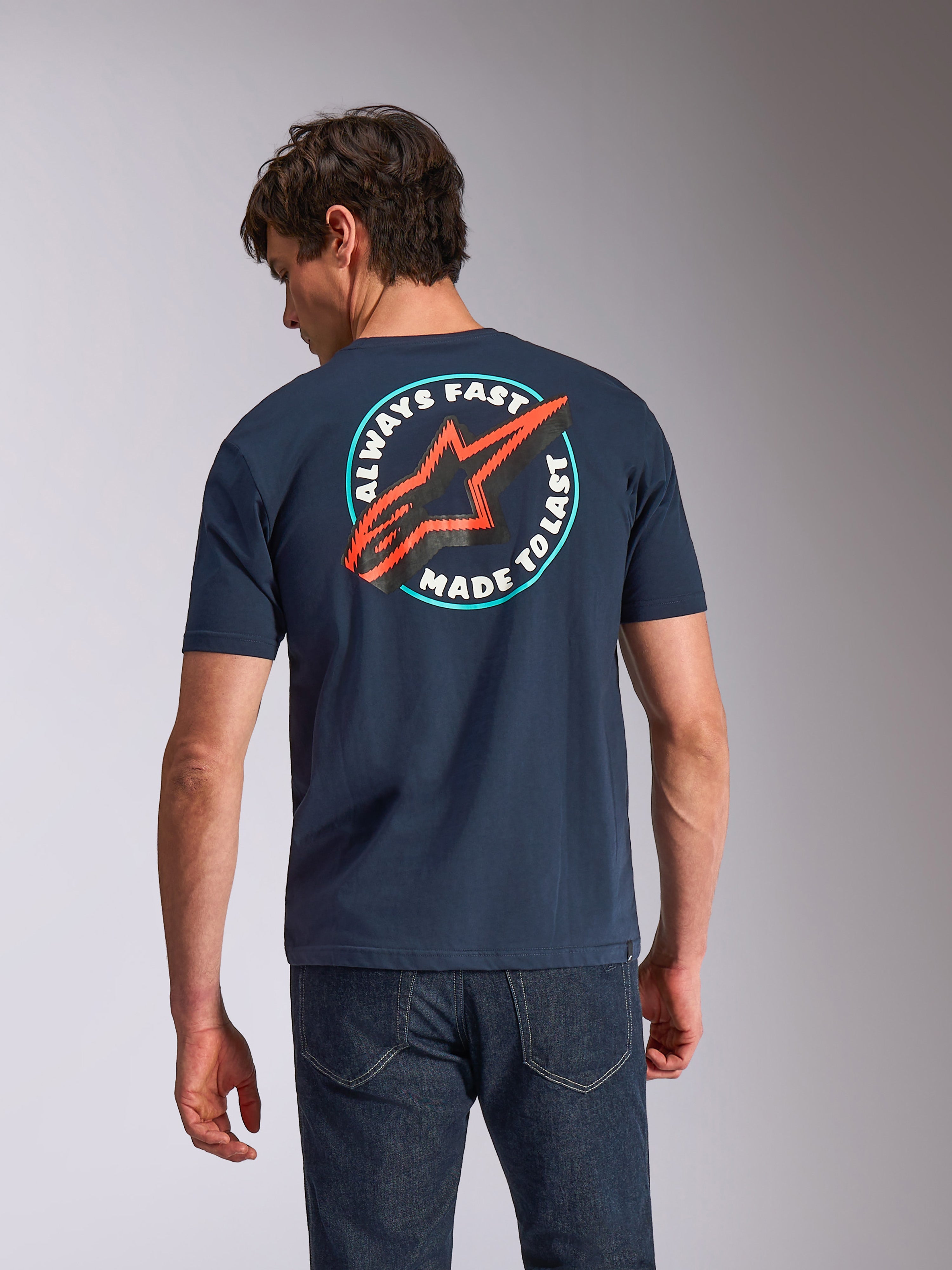 Alpinestars T-shirt Aorbit CSF, maglietta a maniche corte, blu navy, vista posteriore sul modello con grafica circolare 'Always Fast Made to Last' e logo Astars rosso, streetwear casual ispirato al motorsport