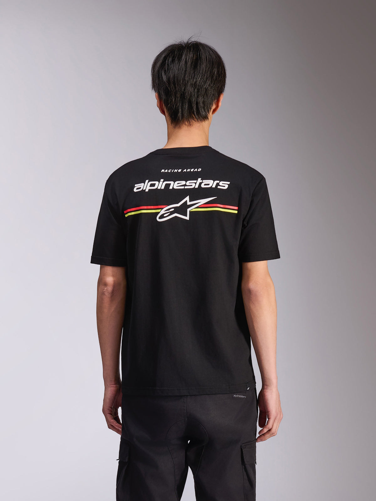 Alpinestars Lanes CSF Tee, t-shirt a maniche corte, nero, vista posteriore con logo Alpinestars bianco e stella Astars con strisce rosse e gialle, streetwear casual motorsport