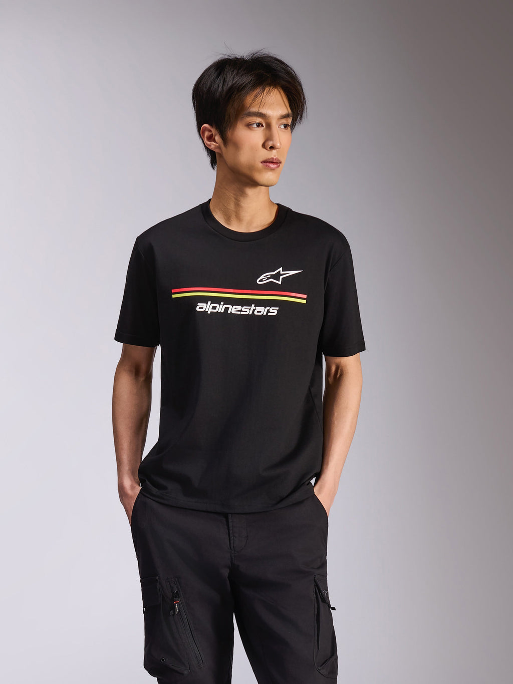 Alpinestars Lanes CSF Tee, t-shirt a maniche corte, nero, loghi Astars e Alpinestars bianchi con strisce orizzontali rosse e gialle, abbigliamento casual motorsport streetwear