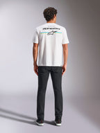 Alpinestars Lanes CSF Tee, t-shirt a maniche corte, bianco, vista posteriore su modello con logo Alpinestars e stella Astars su strisce orizzontali blu e gialle, streetwear casual motorsport