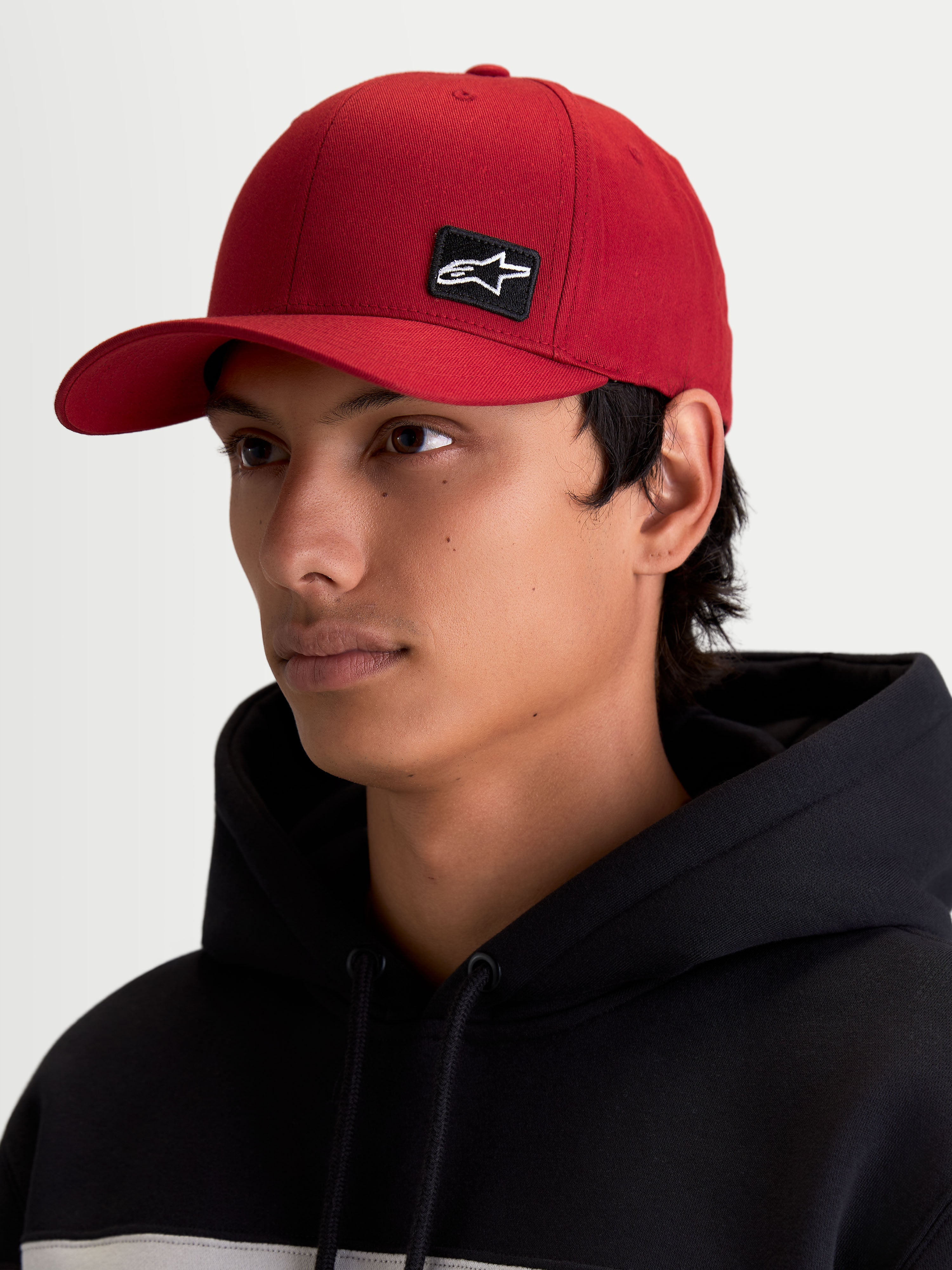 Alpinestars cappello Pivot, cappello sportswear lifestyle unisex, rosso scuro, con visiera curva, corona strutturata e piccola toppa nera con logo Astars ricamato sul davanti, indossato