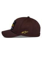 Cappello Alpinestars Matrix Snapback, marrone, vista laterale, visiera curva con dettaglio cordino nero, toppa ricamata frontale, logo Astars giallo laterale, struttura in twill di cotone, copricapo motorsport casual