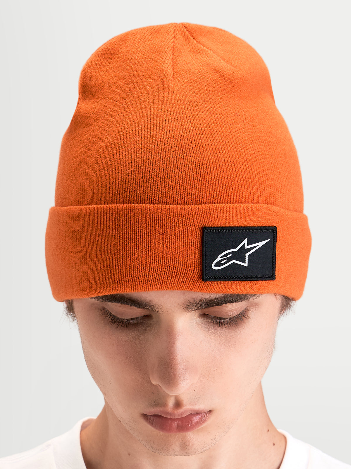 Berretto Alpinestars Augment Cuff, berretto sportivo in maglia, arancione, con risvolto e patch con logo Astars nero, indossato da un modello