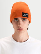 Alpinestars Berretto Augment Cuff, berretto sportswear arancione con patch tessuta del logo Astars, indossato da un modello