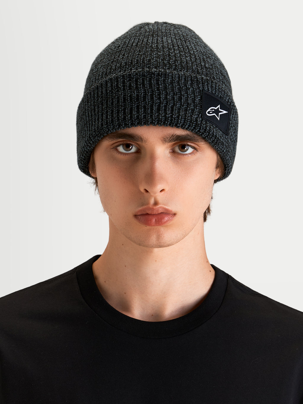 Alpinestars Berretto Unload Rib Cuff, berretto sportswear in grigio melange, indossato da un modello, con design a coste e patch con logo SAstars