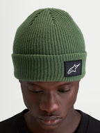 Alpinestars Berretto Unload Rib Cuff, berretto invernale sportswear in maglia, verde pisello, con design a coste e patch tessuta Alpinestars sull'orlo indossato da un modello