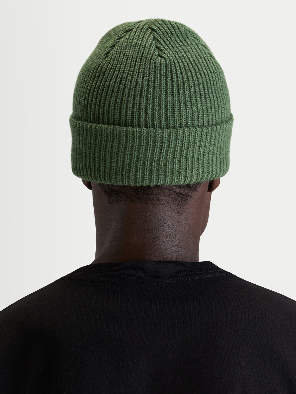 Alpinestars Berretto Unload Rib Cuff, berretto invernale sportswear in maglia, verde pisello, vista posteriore su un modello con t-shirt nera, che mostra la lavorazione a coste e la vestibilità classica