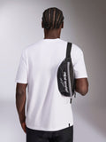 Marsupio Alpinestars Only Linear, nero con logo Alpinestars bianco, indossato a tracolla sopra una t-shirt bianca, accessorio streetwear casual ispirato al motorsport