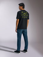 Alpinestars Order CSF Tee, t-shirt a maniche corte, nero, vista posteriore con grafica verde di casco e palme, scritta 'One Goal. One Vision.', streetwear casual motorsport