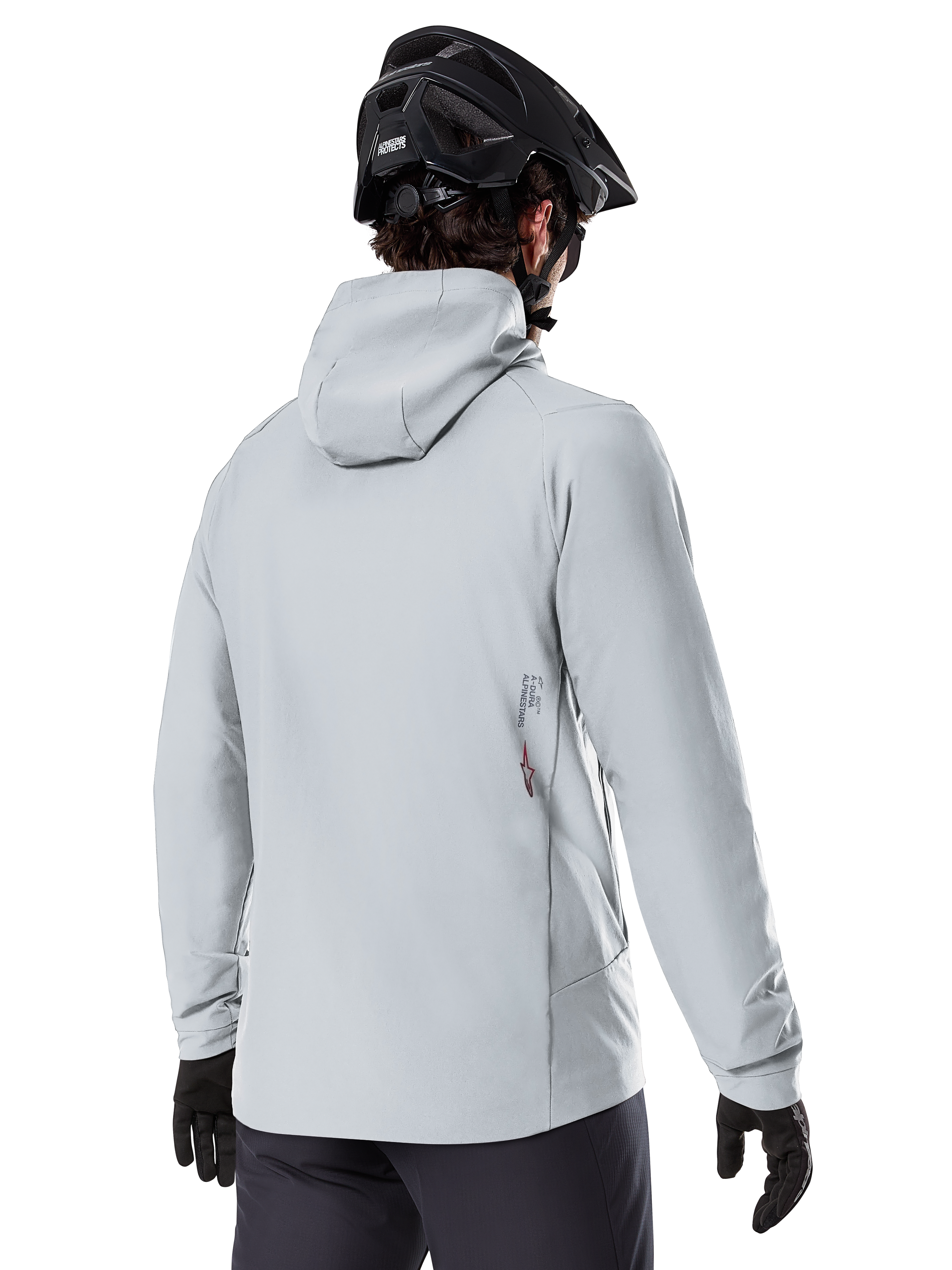 Giacca Termica Alpinestars A-Dura, Grigio Titanio, vista posteriore di un rider che indossa la giacca isolata con cappuccio, abbinata a un casco MTB nero e guanti neri, con un piccolo logo Alpinestars sulla parte inferiore della schiena, progettata per mountain bike in condizioni di freddo