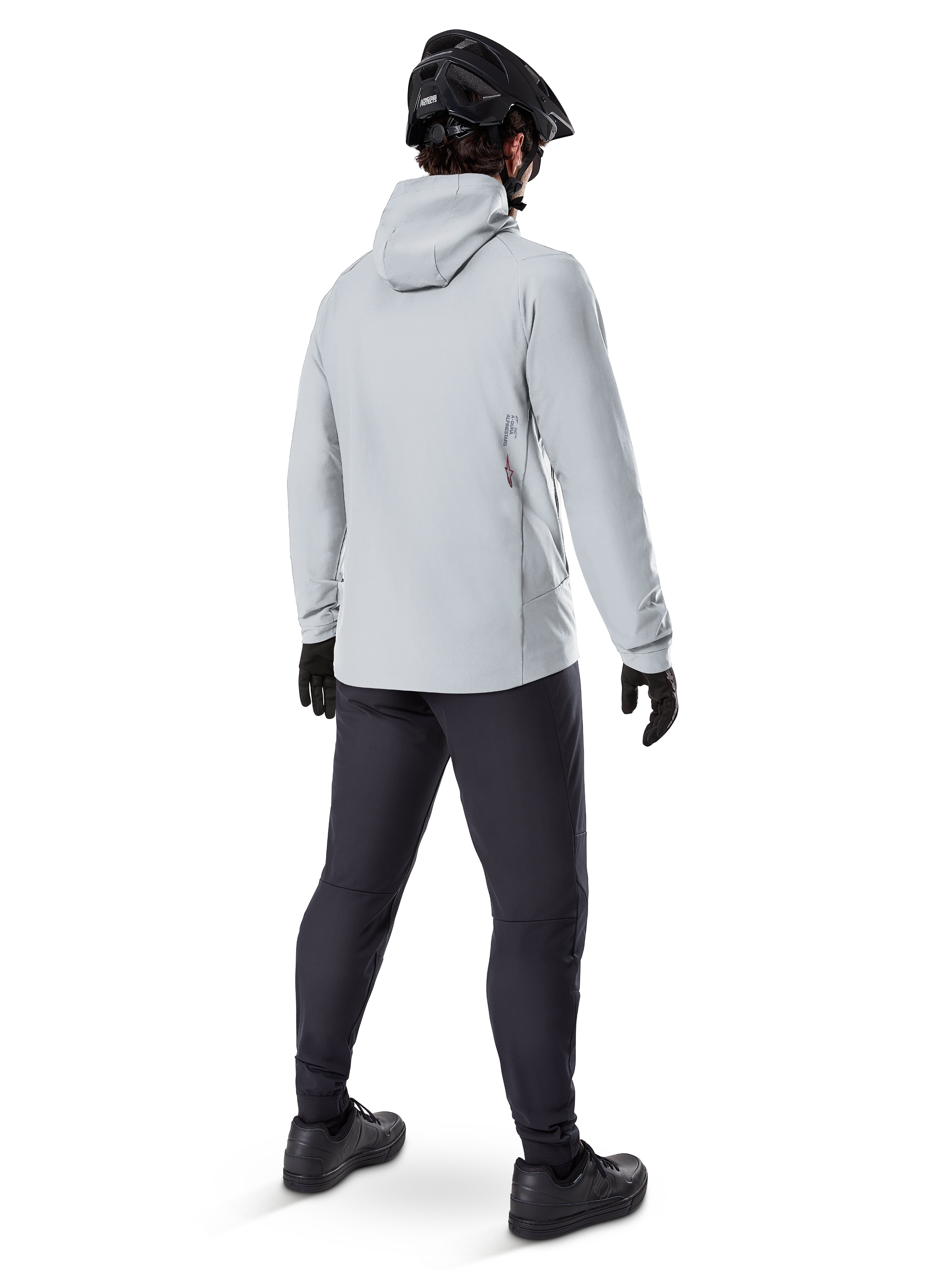 Giacca termica Alpinestars A-Dura in Titanium, vista posteriore di un ciclista che indossa una giacca termica grigio chiaro con cappuccio, abbinata a casco da MTB nero, guanti neri e pantaloni grigio scuro, abbigliamento tecnico per mountain bike