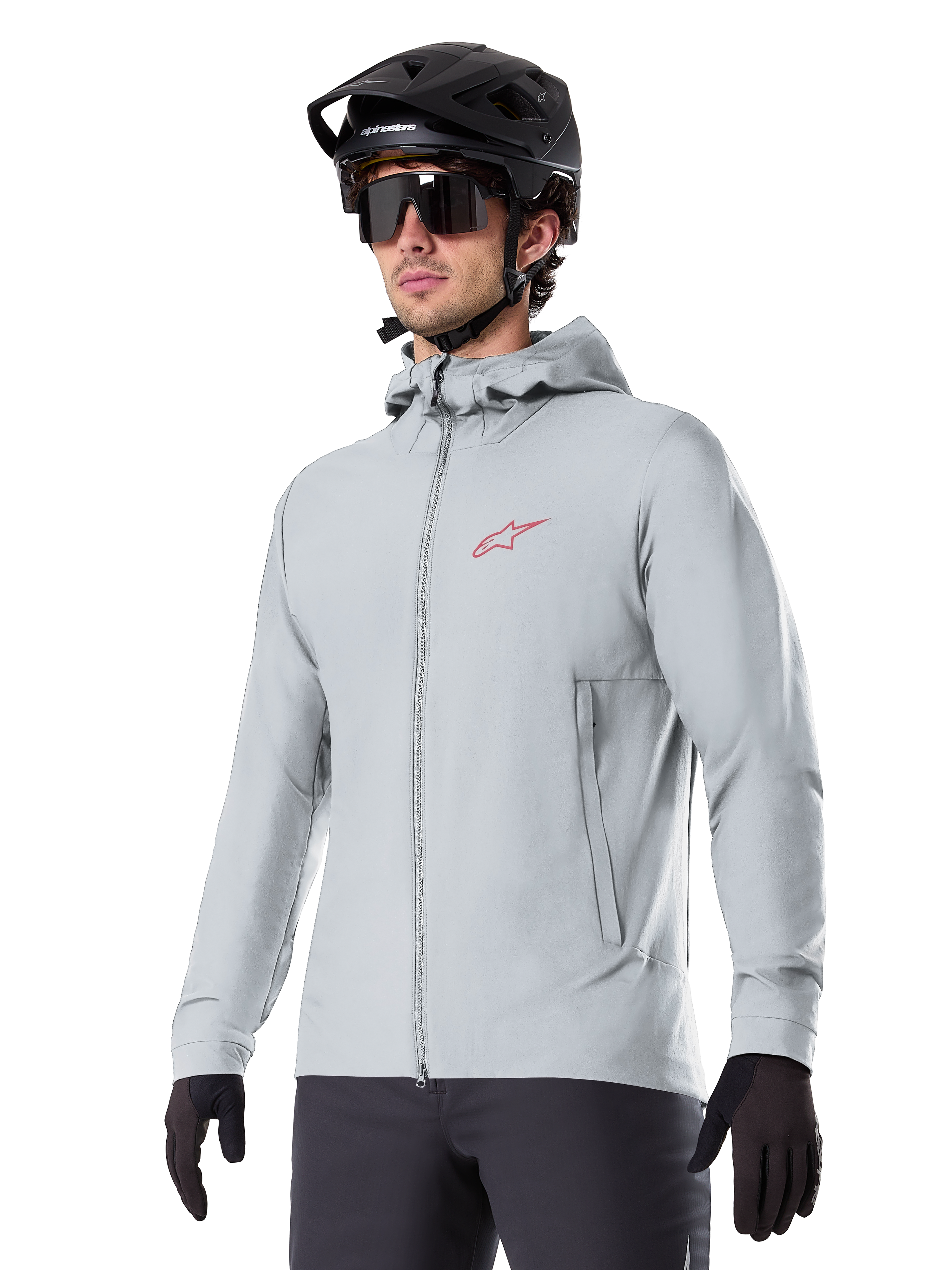 Alpinestars A-Dura Thermal Jacket, giacca termica da ciclismo grigio chiaro, design con cappuccio e piccolo logo rosso, indossata con casco e guanti neri, abbigliamento tecnico da mountain bike per il freddo