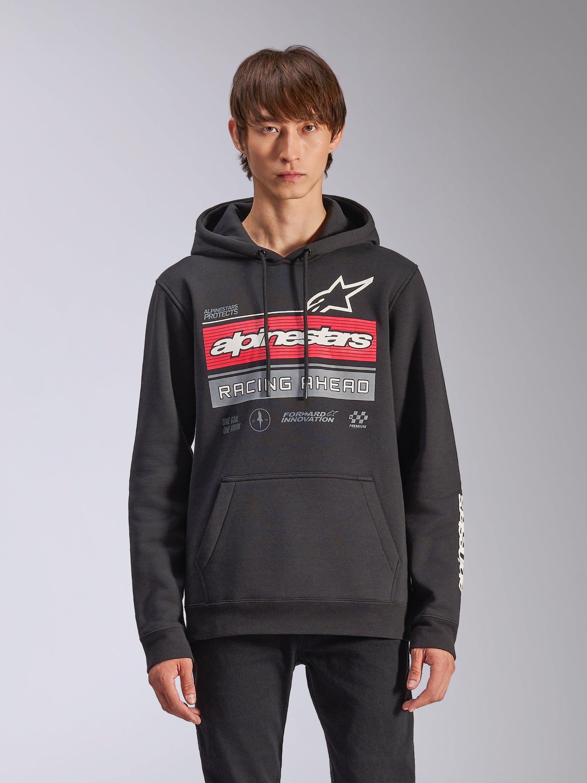 Alpinestars Harken Hoodie, felpa in pile nera modello pullover, con grafica sfumata rossa e grigia, logo Alpinestars e scritta 'Racing Ahead', tasca a marsupio, cappuccio con cordino e branding sulle maniche, design casual ispirato al motorsport