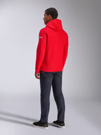 Felpa con cappuccio Alpinestars Frontal, felpa pullover in pile rossa, vista posteriore con logo testuale bianco sulla manica, indossata con pantaloni in denim scuro e scarpe nere, streetwear casual motorsport