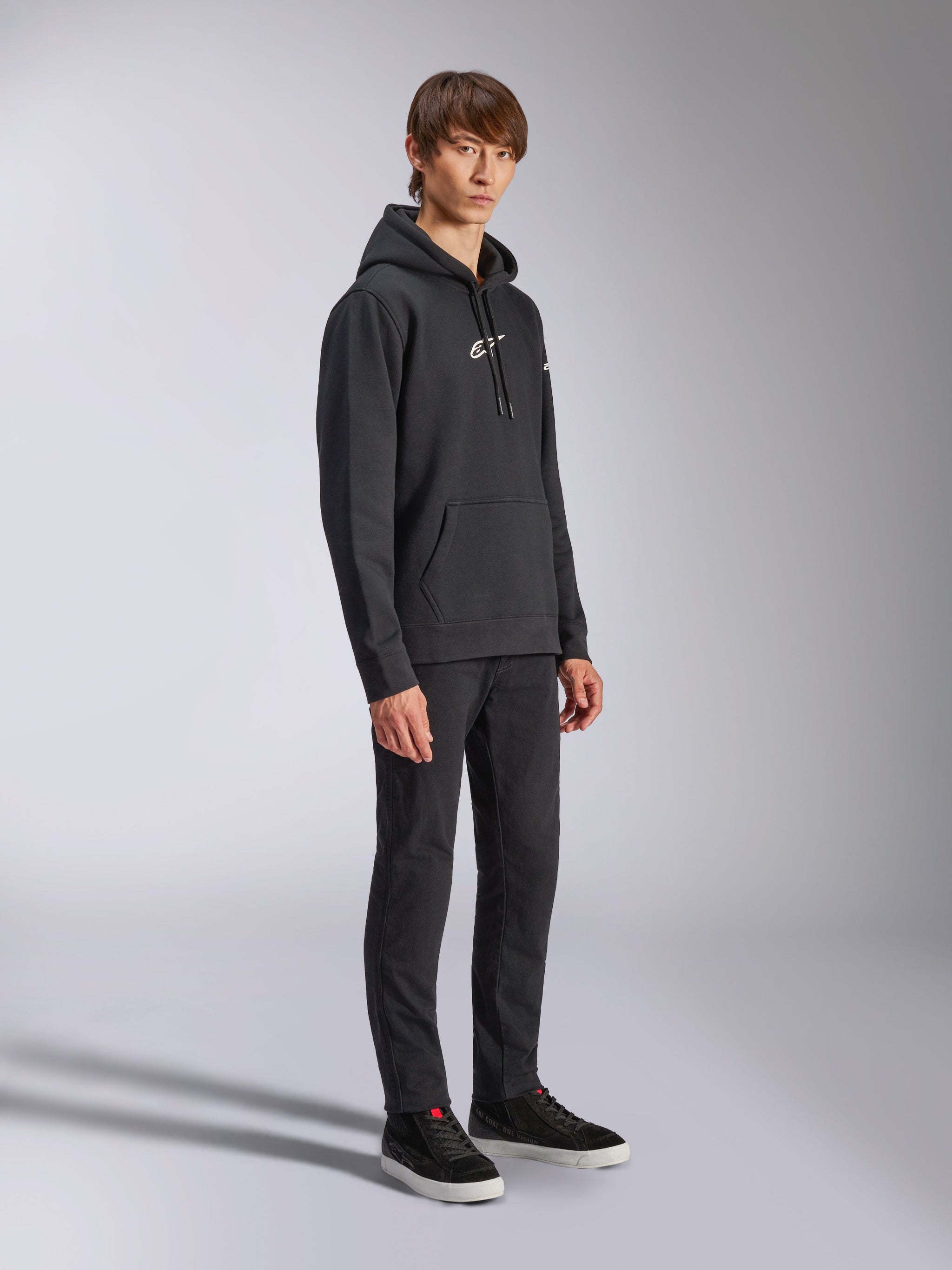 Alpinestars Felpa con cappuccio Frontal, nero, felpa in pile a pullover con logo HD bianco sul petto e loghi con marchio sulle maniche, tasca a marsupio, indossata con pantaloni neri e sneakers, streetwear casual ispirato al motorsport