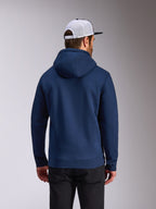 Alpinestars Frontal Hoodie, felpa con cappuccio in pile blu navy, vista posteriore di abbigliamento casual streetwear, indossata con pantaloni neri e cappellino in mesh bianco e nero, design moderno ispirato al motorsport