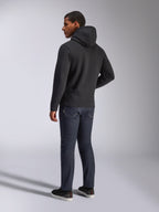 Felpa con cappuccio Alpinestars Blaze V3, vista posteriore di un uomo che indossa la felpa nera, abbinata a jeans scuri e sneakers nere, streetwear casual ispirato al motorsport