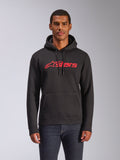 Alpinestars Blaze V3 Hoodie, felpa da uomo in pile modello pullover, nera con logo Alpinestars rosso, indossata da un uomo con jeans scuri, dotata di cappuccio con cordino e tasca a marsupio, streetwear casual ispirato al motorsport