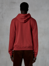 Alpinestars Essentials Ageless Zip Hoodie, rosso mattone, vista posteriore che mostra la vestibilità rilassata e il cappuccio con coulisse, indossata con pantaloni in velluto a coste marroni, streetwear casual ispirato al motorsport