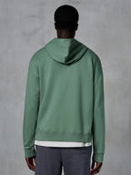 Alpinestars Essentials Ageless Zip Hoodie, vista posteriore su modello, verde Cactus, streetwear casual ispirato al motorsport, vestibilità rilassata con orlo e polsini a costine, pile compatto di alta qualità