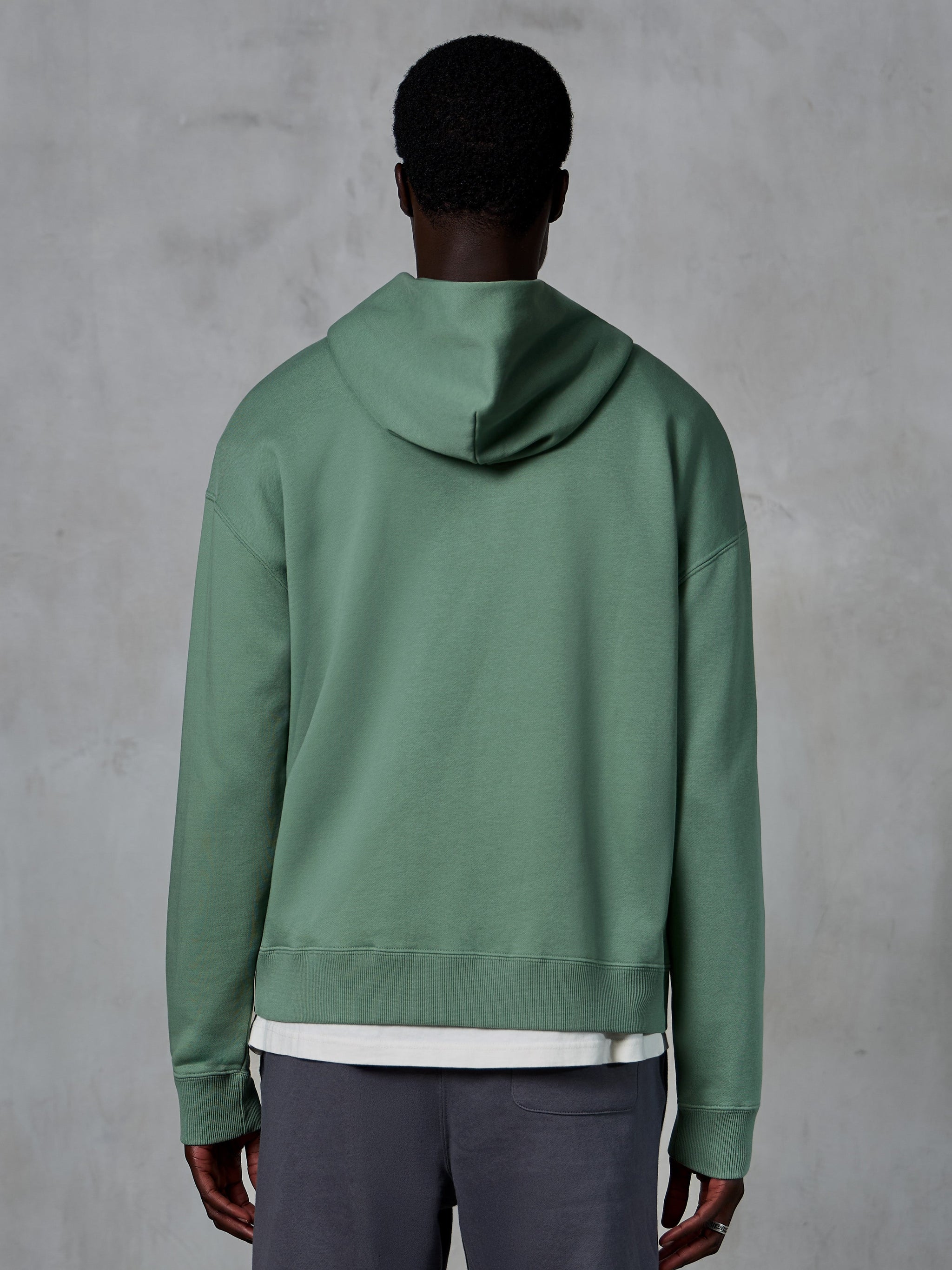 Alpinestars Essentials Ageless Zip Hoodie, vista posteriore su modello, verde Cactus, streetwear casual ispirato al motorsport, vestibilità rilassata con orlo e polsini a costine, pile compatto di alta qualità