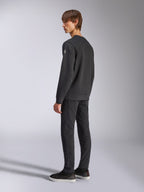 Alpinestars Bettern Crew, felpa girocollo in pile, nero, modello maschile inquadrato di schiena e di lato, con polsini e orlo a coste e un piccolo logo sulla manica, abbigliamento casual streetwear ispirato al motorsport