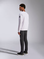 Alpinestars Bettern Crew, felpa girocollo bianca, vista posteriore e laterale, logo circolare nero sulla manica, indossata con pantaloni grigio scuro e sneakers nere, streetwear casual lifestyle motorsport