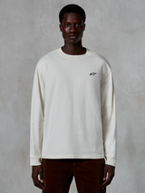 Alpinestars Essentials Ageless LS Tee, t-shirt a maniche lunghe, bianco sporco, piccolo logo a stella nero sul petto, streetwear casual, vestibilità rilassata, indossata da un modello