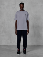 T-shirt Alpinestars Essentials Ageless SS, maglietta a maniche corte, Silver, con un piccolo logo nero sul petto, abbinata a joggers e sneakers neri, streetwear casual ispirato al motorsport