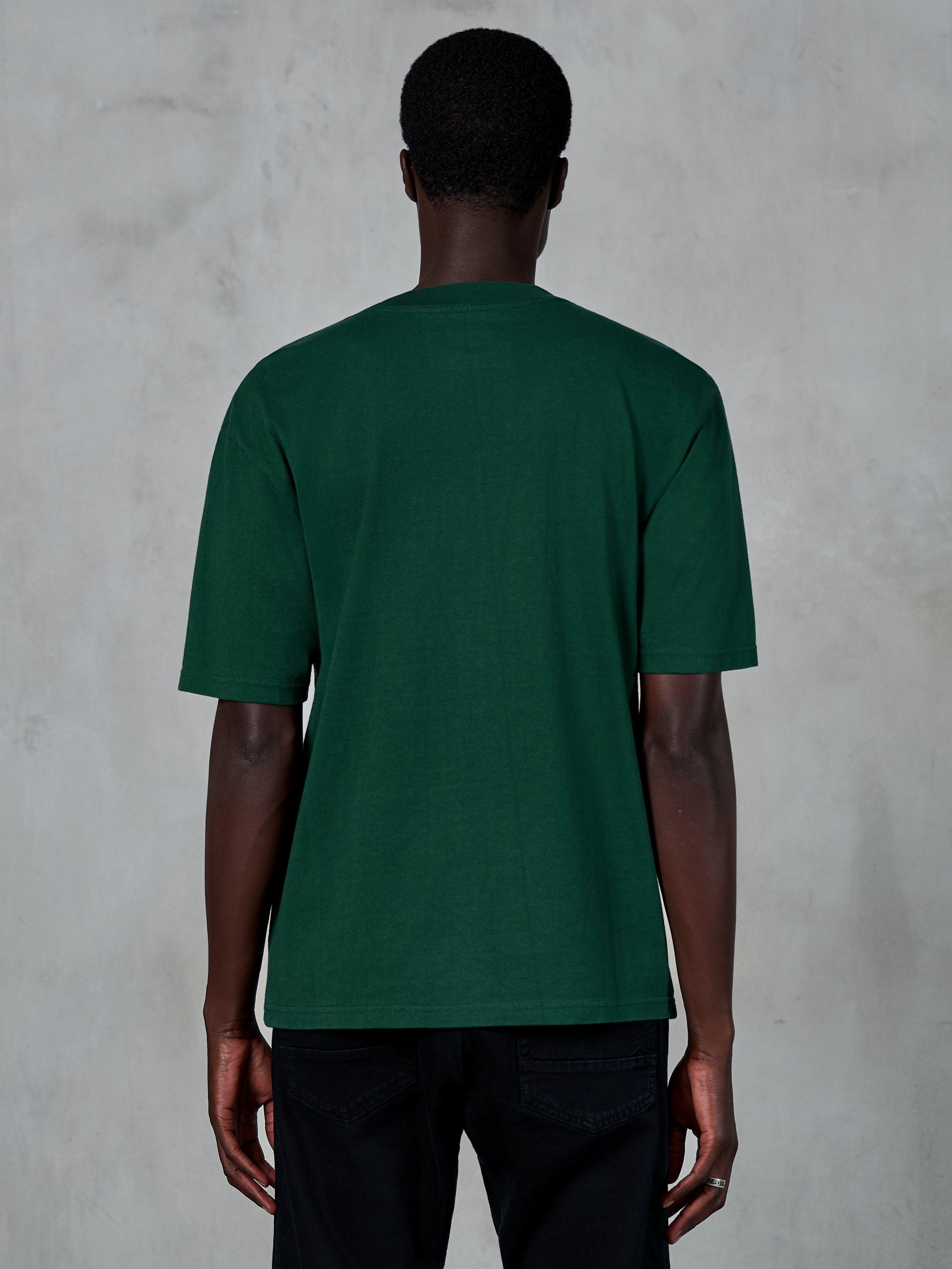 Alpinestars Essentials Ageless SS Tee, maglietta a maniche corte, verde pino, vista posteriore su modello, vestibilità rilassata, cotone organico, streetwear casual ispirato al motorsport